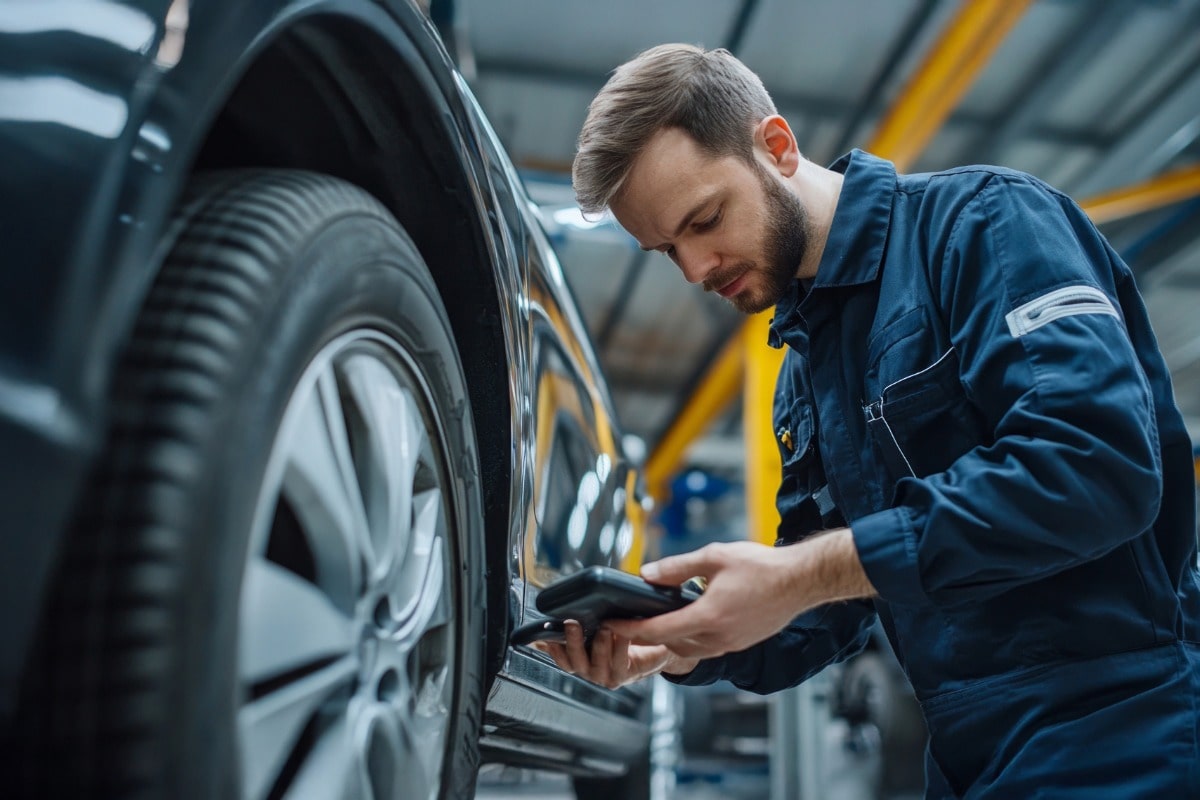 KFZ Mitarbeiter checkt einen Reifen